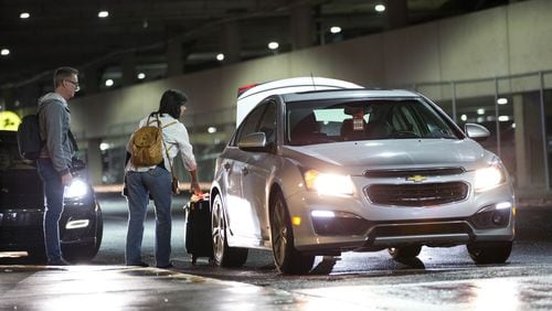 Passengers load their luggage into an Uber driver's car at the designated rideshare area at Hartsfield-Jackson Atlanta International Airport , Monday, Jan. 2, 2017, in Atlanta. BRANDEN CAMP/SPECIAL