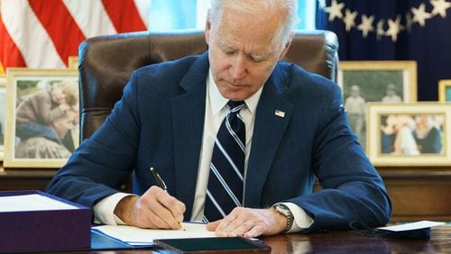 President Joe Biden signs the American Rescue Plan in the Oval Office. (Mandel Ngan/AFP/TNS)