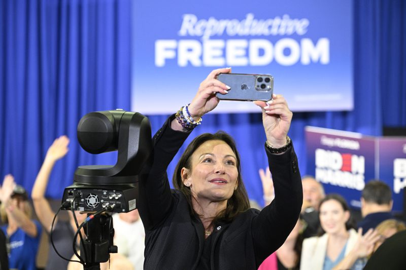 Florida Democratic Party Chair Nikki Fried makes a selfie photo with attendees waiting to hear President Joe Biden speak during a reproductive freedom campaign event at Hillsborough Community College, Tuesday, April 23, 2024, in Tampa, Fla. (AP Photo/Phelan M. Ebenhack)