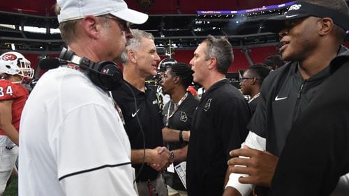 North Gwinnett head coach Bill Stewart (center left) and Colquitt County head coach Justin Rogers shake hands after Colquitt County won 17- 6 during the Corky Kell Classic at Mercedes-Benz Stadium on Saturday, August 24, 2019. (Hyosub Shin / Hyosub.Shin@ajc.com)