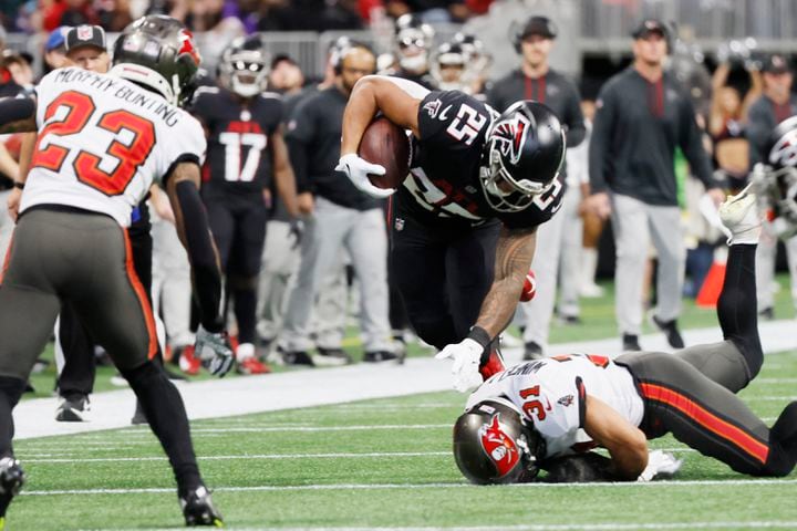 Falcons running back Tyler Allgeier goes airborne after a tackle by Buccaneers safety Antoine Winfield during the second quarter Sunday in Atlanta. (Miguel Martinez / miguel.martinezjimenez@ajc.com)