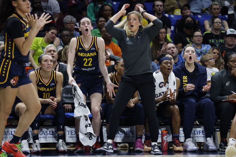 Indiana Fever guard Caitlyn Clark (22) and head coach Christine Sides, center right, react after a play during the second half of an WNBA basketball game against the Dallas Wings in Arlington, Texas, Friday, May 3, 2024. (AP Photo/Michael Ainsworth)