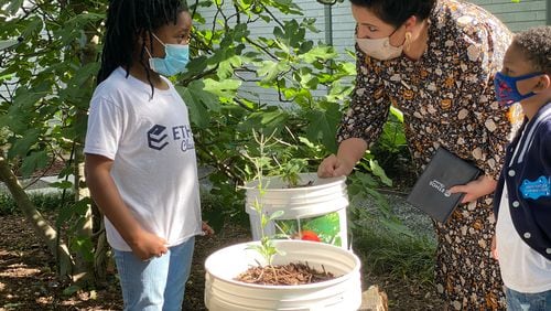 Principal Emily Castillo Leon of Ethos Classical Charter School, is working with students in the school’s garden. Ethos is one of the schools that RedefinED Atlanta has given grants to this year. Courtesy of RedefinED Atlanta