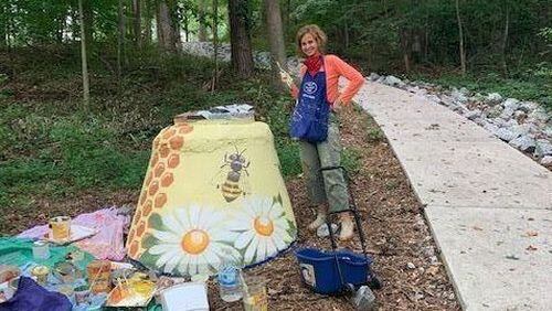 Dr. Angelika Domschke is using her painting talents to make otherwise unsightly manholes more enjoyable along the Hunter-Walker Trail in Norcross.