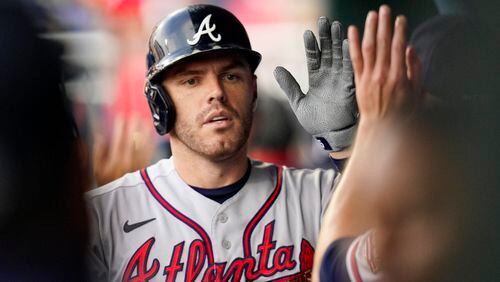 Atlanta Braves' Freddie Freeman is congratulated for his two-run home run during the first inning of the team's baseball game against the Philadelphia Phillies, Saturday, July 24, 2021, in Philadelphia. (AP Photo/Chris Szagola)
