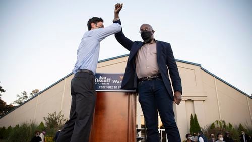 Democratic candidates Jon Ossoff, left, and the Rev. Raphael Warnock bump elbows on stage at a rally in Jonesboro, Georgia, on November 19, 2020. (Robin Rayne/Zuma Press/TNS)