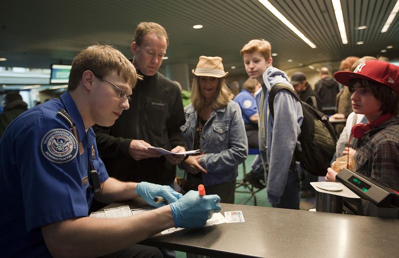Passengers line up to a Transportation Security Administration (TSA) officer to go through airport security at Portland International Airport (PDX).  (Photo by Natalie Behring/Getty Images)