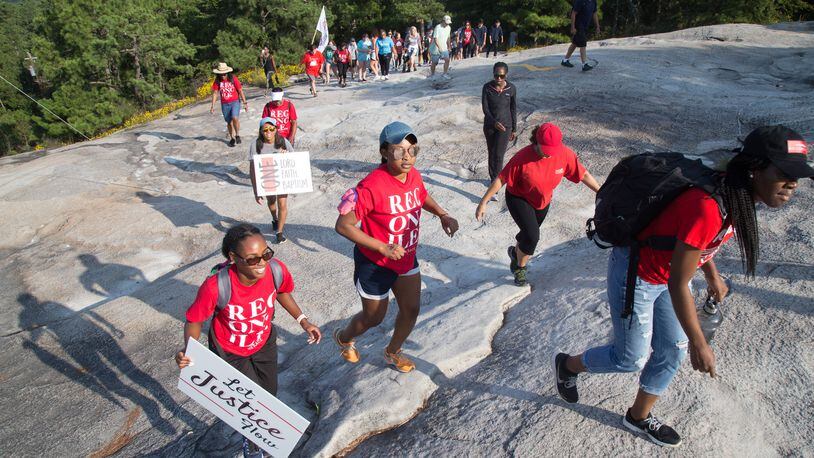 Participants in a racial reconciliation event at Stone Mountain on Saturday make their way to the top of the edifice. STEVE SCHAEFER / SPECIAL TO THE AJC