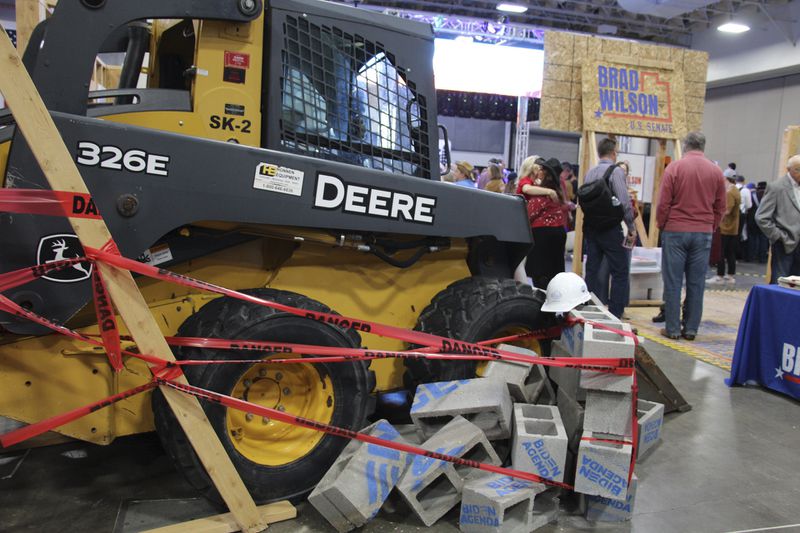 A campaign display for former Utah state House Speaker Brad Wilson, who is running for the U.S. Senate seat Mitt Romney is vacating, shows a tractor clearing away concrete blocks labeled "Biden Agenda" at the Utah Republican Party Convention, April 27, 2024, in Salt Lake City, Utah. (AP Photo/Hannah Schoenbaum)