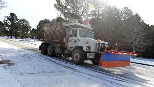 A Dekalb County sand truck spreads salt and sand along Snapfinger Woods Drive near Miller Road Wednesday. The Atlanta metro area continues to suffer under the grip of snow and ice covered roads for a second day Wednesday, January 29, 2014, after a mid-day storm paralyzed the area Tuesday.