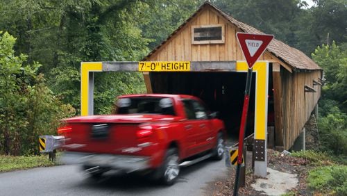 The Concord Covered Bridge over Nickajack Creek has a low clearance and gets hit multiple times per year, usually by rented trucks that don’t clear the warning beam. BOB ANDRES / BANDRES@AJC.COM