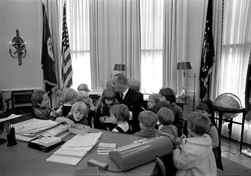 Head Start children surround President Johnson at his desk in the Oval Office. (Head Start)