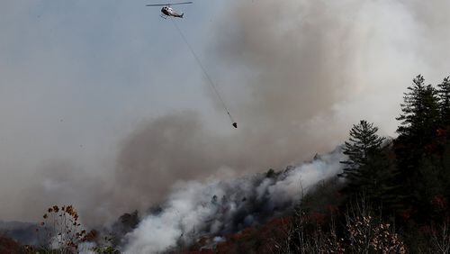 A helicopter drops water on the Rock Mountain fire as it approaches homes on Wednesday, Nov. 16, 2016, in Tate City. (Curtis Compton/ccompton@ajc.com)