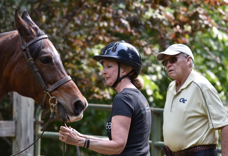 Robin Chisolm-Seymour, holding her horse Jabez, says her husband, Stuart Seymour, has been supportive as she dealt with hearing loss. HYOSUB SHIN / HSHIN@AJC.COM