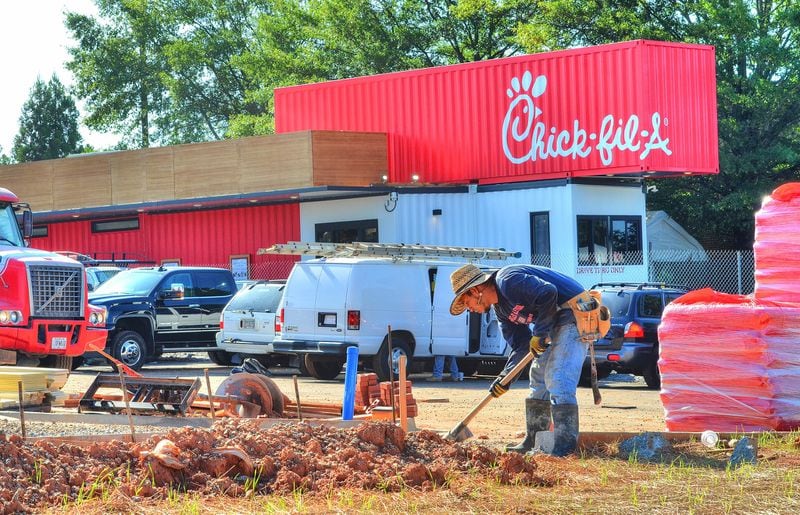 The temporary Chick-fil-A (background red boxes) in Newnan is being used to serve customers while the new Chick-fil-A is under construction. The temporary Chick-fl-A was made from multiple shipping containers and is a drive-thru only version of the restaurant. (Chris Hunt/Special)