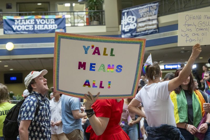 Participants speak to each other while holding signs up during an LGBTQ protest Monday at Georgia Southern University. (AJC Photo/Katelyn Myrick)