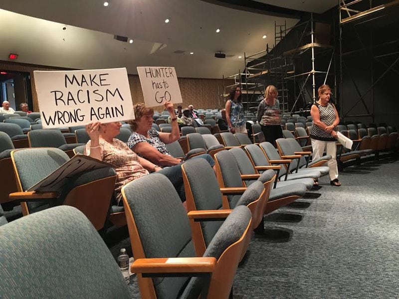 Protesters attend Tuesday afternoon’s meeting of the Gwinnett County Board of Commissioners to call for the resignation of Commissioner Tommy Hunter, who was reprimanded last week by his colleagues. TYLER ESTEP / TYLER.ESTEP@AJC.COM