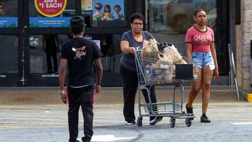 Tyana Baker (right) and her mother, Theresa Baker, head to their car after picking up groceries at a Kroger in Stone Mountain. The grocery giant recently met with customers of the Kroger store on Metropolitan Parkway to discuss concerns about the condition of the store. STEVE SCHAEFER / SPECIAL TO THE AJC