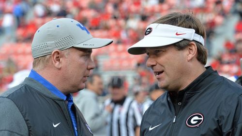 Georgia coach Kirby Smart (right) and Kentucky coach Mark Stoops talk before the start of a game on Nov. 18, 2017, in Athens. (Hyosub Shin/Atlanta Journal-Constitution/TNS)