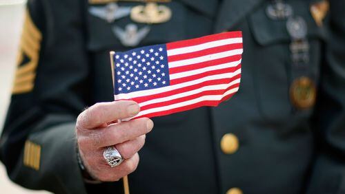 Army special forces vet Tony Junot holds an American flag during a Veterans Day ceremony November 12, 2007 in Miami Beach, Florida. Veterans Day honors military veterans from all wars that the United States has fought.  (Photo by Joe Raedle/Getty Images)