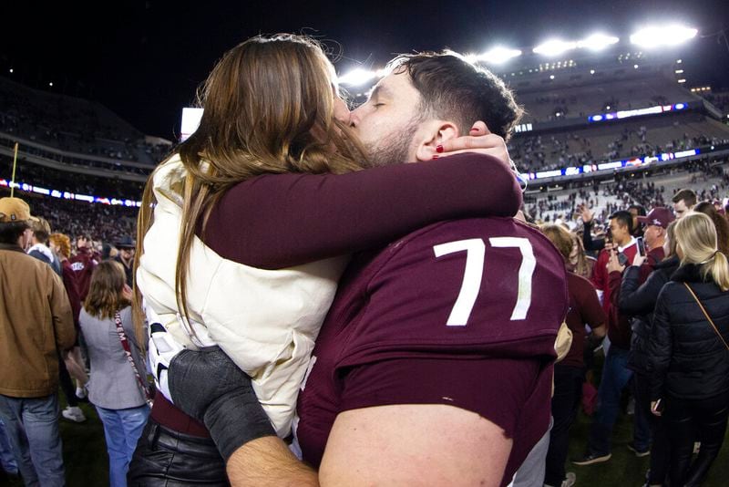 Texas A&M Aggies offensive lineman Matthew Wykoff (77) gets a kiss after the team's NCAA college football game against LSU on Saturday, Nov. 26, 2022, in College Station, Texas. Texas A&M won 38-23. (Logan Hannigan-Downs/College Station Eagle via AP)