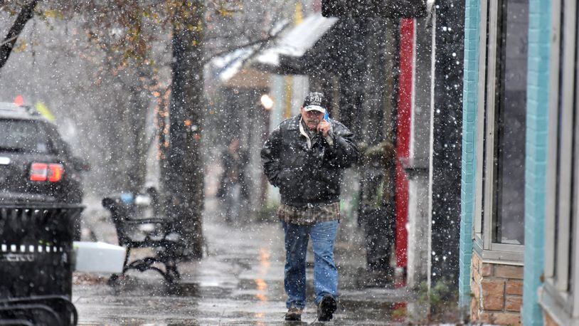 A pedestrian makes his way as a wintry mix of sleet and snow is falling in East Atlanta Village. HYOSUB SHIN / HSHIN@AJC.COM