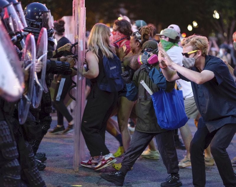 Protesters dodge tear gas deployed by police after the 9 p.m. curfew in downtown Atlanta on June 2, 2020. Rallies and marches, often marred by violence, continued for a fourth day in Atlanta amid nationwide and global demonstrations over the death of George Floyd while in Minneapolis police custody. (Ben Gray for the Atlanta Journal Constitution)