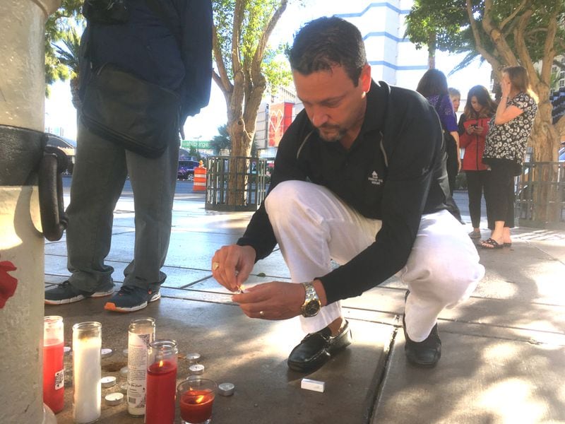 Steve Titzer lights a candle in memory of the Vegas shooting victims. Photo: Jennifer Brett