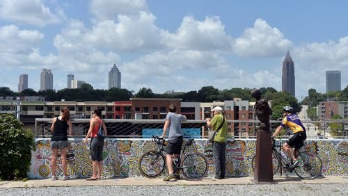 August 23, 2014 Atlanta - Runners, walkers and bikers stop and watch skyline on the Atlanta Beltline’s Eastside Trail on Saturday, August 23, 2014. A story on the growing preponderance of bells — specifically bicycle bells — on the Atlanta Beltline. Till now he semi-polite tug of war for space between cyclists and everyone else, like walkers and runners, has been dominated by shrieks of “On Your Left!” as the bikers try to pass. But observation suggests more and more of them are reverting to childhood and tinkling bells on their handlebars. HYOSUB SHIN / HSHIN@AJC.COM Beltline Book 083015