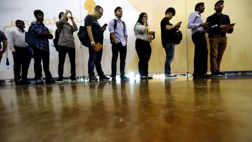 Job seekers line up to speak to recruiters during a job fair this fall. (AP Photo/LM Otero)