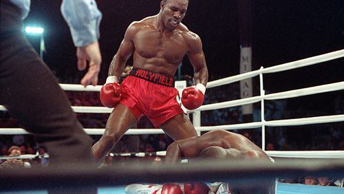 Evander Holyfield strikes the pose of a champion over the fallen Buster Douglas. (AP Photo/Douglas C. Pizac)