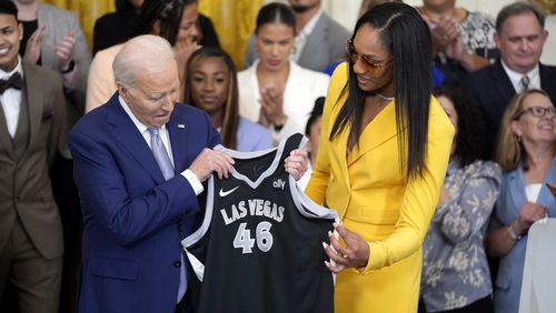 A'ja Wilson, of the WNBA's Las Vegas Aces, right, presents a jersey to President Joe Biden during an event to celebrate the 2023 WNBA championship team, in the East Room of the White House, Thursday, May 9, 2024, in Washington. (AP Photo/Evan Vucci)