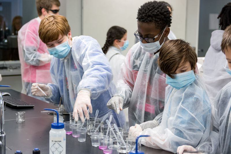 A team of young public health investigators complete a laboratory test to identify the cause of a mock zombie disease during the Outbreak Game at Emory University during a Atlanta Science Festival.