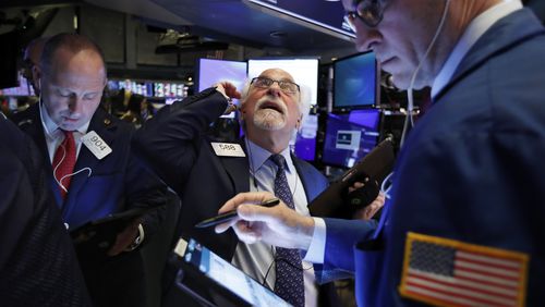 Traders Michael Urkonis, left, and Peter Tuchman, center, work on the floor of the New York Stock Exchange, Monday, Feb. 24, 2020. Stocksfell sharply on Wall Street as coronavirus cases spread beyond China, threatening to disrupt the global economy. (AP Photo/Richard Drew)