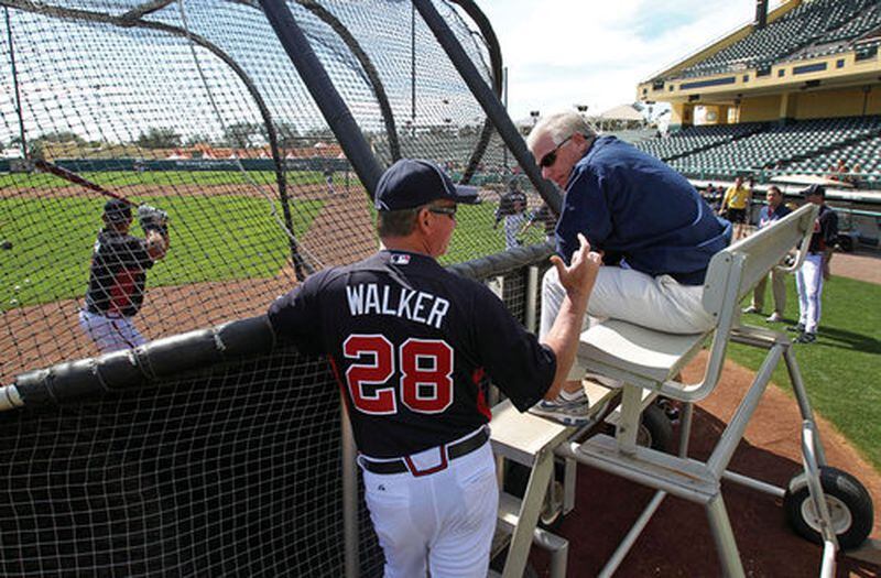 Feb. 20, 2012- LAKE BUENA VISTA, FL: New Atlanta Braves hitting coach Greg Walker talks with Atlanta Braves Executive Vice President &amp; GM Frank Wren as they watch batting practice during the first day of pitchers and catchers workouts at Champion Stadium in the ESPN Wide World of Sports Complex Monday morning in Lake Buena Vista, Fl., Feb. 20, 2012. Jason Getz jgetz@ajc.com The former hitting coach meets with the former GM. (Jason Getz/AJC photo)