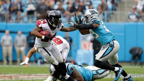Falcons running back Devonta Freeman runs the ball against Panthers safety Mike Adams #29 in the fourth quarter during their game Sunday at Bank of America Stadium in Charlotte, North Carolina.