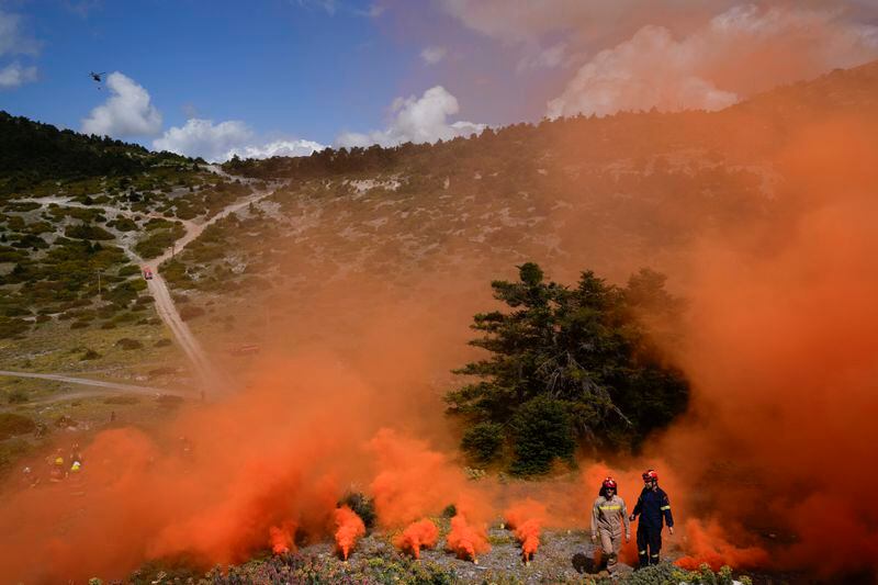 Firefighters of the 1st Wildfire Special Operation Unit and firefighters in training for the special unit, take part in a drill in Villia village some 60 kilometers (37 miles) northwest of Athens, Greece, Friday, April 19, 2024. Greece's fire season officially starts on May 1 but dozens of fires have already been put out over the past month after temperatures began hitting 30 degrees Celsius (86 degrees Fahrenheit) in late March. This year, Greece is doubling the number of firefighters in specialized units to some 1,300, adopting tactics from the United States to try and outflank fires with airborne units scrambled to build breaks in the predicted path of the flames. (AP Photo/Thanassis Stavrakis)