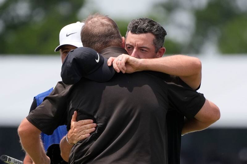 Rory McIlroy, of Northern Ireland, facing, congratulates teammate Shane Lowry, of Ireland, after finishing the day on the ninth green during the second round of the PGA Zurich Classic golf tournament at TPC Louisiana in Avondale, La., Friday, April 26, 2024. (AP Photo/Gerald Herbert)