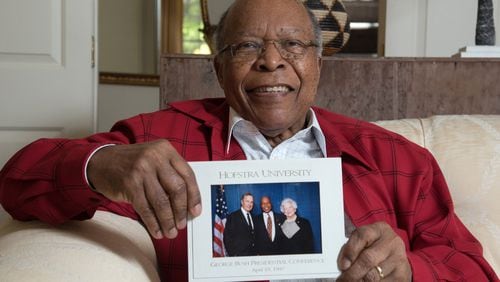 Dr. Louis Sullivan, of Atlanta, holds his photograph with the late President George H.W. Bush and the late Barbara Bush that was taken in 1997. Sullivan was appointed by Bush and served as the secretary of the U.S. Department of Health and Human Services from 1989 to 1993. He was the founding president of Morehouse School of Medicine. HYOSUB SHIN / HSHIN@AJC.COM