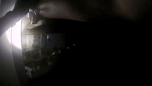 A still photo lifted from body camera footage of the fatal shooting of Robert Maike by a Heard County sheriff's deputy. Maike can be seen sitting on his porch near the center of the deputy's flashlight beam with a strap over his right shoulder.