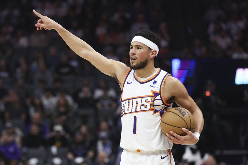 Phoenix Suns guard Devin Booker (1) gestures during the first half of an NBA basketball game against the Sacramento Kings Friday, April 12, 2024, in Sacramento, Calif. (AP Photo/Benjamin Fanjoy)