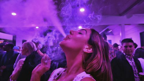 FILE - A guest takes a puff from a marijuana cigarette at the Sensi Magazine party celebrating the 420 holiday in the Bel Air section of Los Angeles, April 20, 2019. Marijuana advocates are gearing up for Saturday, April 20, 2024. Known as 4/20, marijuana's high holiday is marked by large crowds gathering in parks, at festivals and on college campuses to smoke together. This year, activists can reflect on how far the movement has come. (AP Photo/Richard Vogel, File)