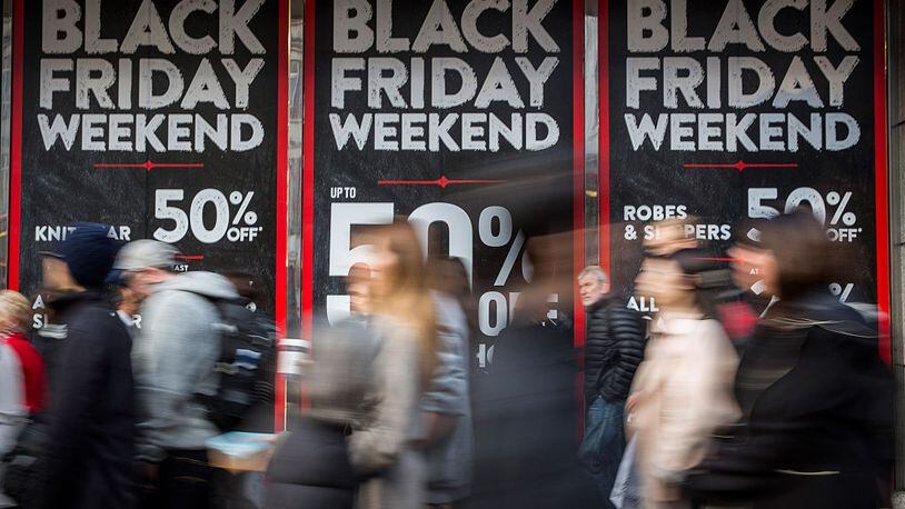 LONDON, ENGLAND - NOVEMBER 28:  People walk past a shopfront on Oxford Street advertising 'Black Friday' discounts on November 28, 2014 in London, England.  Originating in the USA as a sales day that following the Thanksgiving holiday, 'Black Friday' is becoming an increasingly popular shopping day in the UK.  (Photo by Rob Stothard/Getty Images)