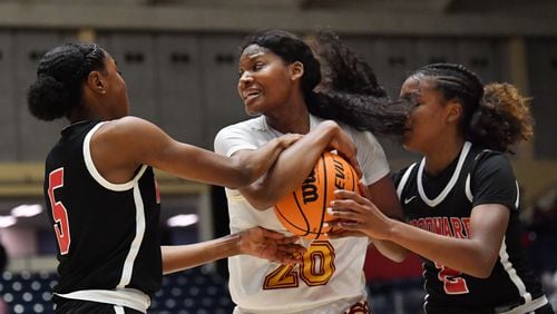 March 11, 2021 Macon - Forest Park's Sania Feagin (20) holds onto the ball as Woodward Academy's Savannah Simms (5) and Woodward Academy's Sara Lewis (2) try to steal during the 2021 GHSA State Basketball Class AA Boys Championship game at the Macon Centreplex in Macon on Thursday, March 11, 2021 Pace Academy won 73-42 over Columbia. (Hyosub Shin / Hyosub.Shin@ajc.com)