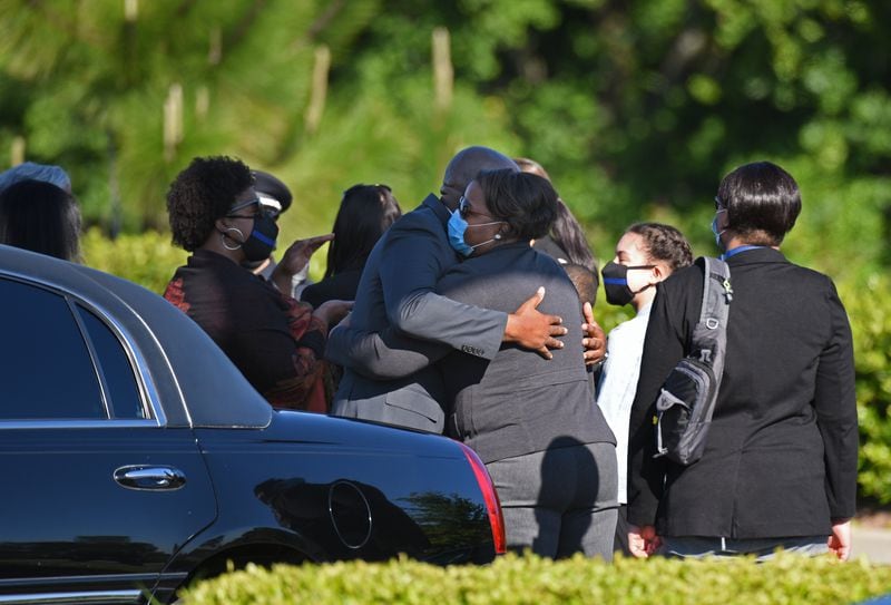 Family members and guests embrace at a parking lot of the Truist Park before the start of the funeral service for Smyrna Officer Christopher Ewing on Friday, May 1, 2020. (Hyosub Shin / Hyosub.Shin@ajc.com)