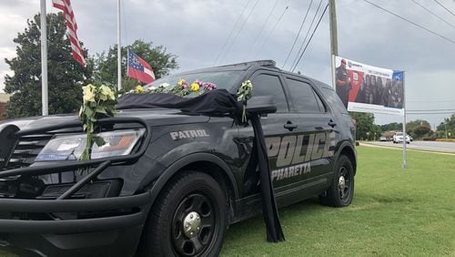Clinton Martin was a beloved officer, colleagues say. Following his death, police placed his patrol car in front of the Alpharetta Department of Public Safety building and adorned it with photos and memories from fellow officers. Courtesy Alpharetta Department of Public Safety Facebook