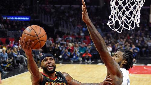 Atlanta Hawks guard Malcolm Delaney, left, shoots as Los Angeles Clippers center DeAndre Jordan defends during the second half of a basketball game, Monday, Jan. 8, 2018, in Los Angeles. The Clippers won 108-107. (AP Photo/Mark J. Terrill)