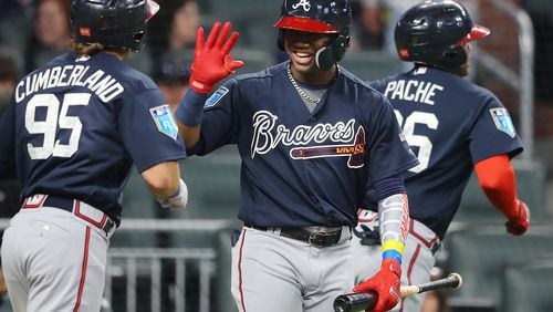 Braves' Ronald Acuna Jr. gives outfielder Cristian Pache (right) and Brett Cumberland (left) high fives at home plate after Pache hit a 2-run homer off pitcher Sean Newcomb.  Curtis Compton/ccompton@ajc.com
