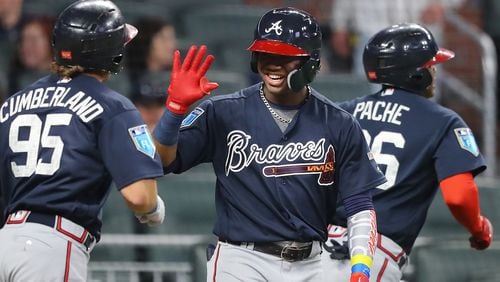 Ronald Acuna gives outfielder Cristian Pache (right) and Brett Cumberland (left) high fives at home plate after Pache hit a 2-run homer off pitcher Sean Newcomb to tie the game 2-2 during the third inning in the Future Stars Exhibition Game on Tuesday, March 27, 2018, at SunTrust Park in Atlanta.  Curtis Compton/ccompton@ajc.com