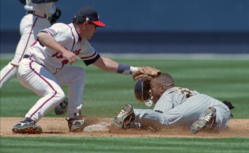 Pittsburgh Pirates baserunner Al Martin slides into second base under a tag from Mark Lemke during a 1997 game at Turner Field in Atlanta.